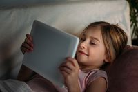sick child watches movie on tablet in bed