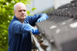 Man performing gutter repairs and maintenance